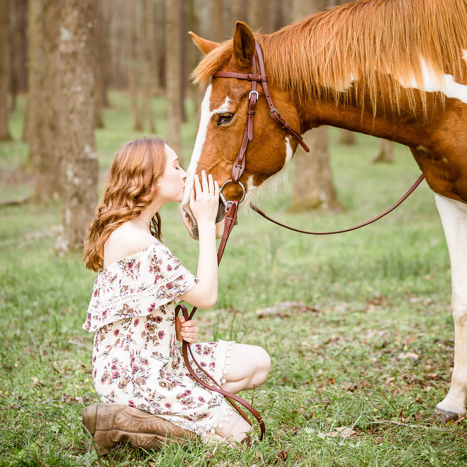 high school senior girl kissing paint horse in green spring forest