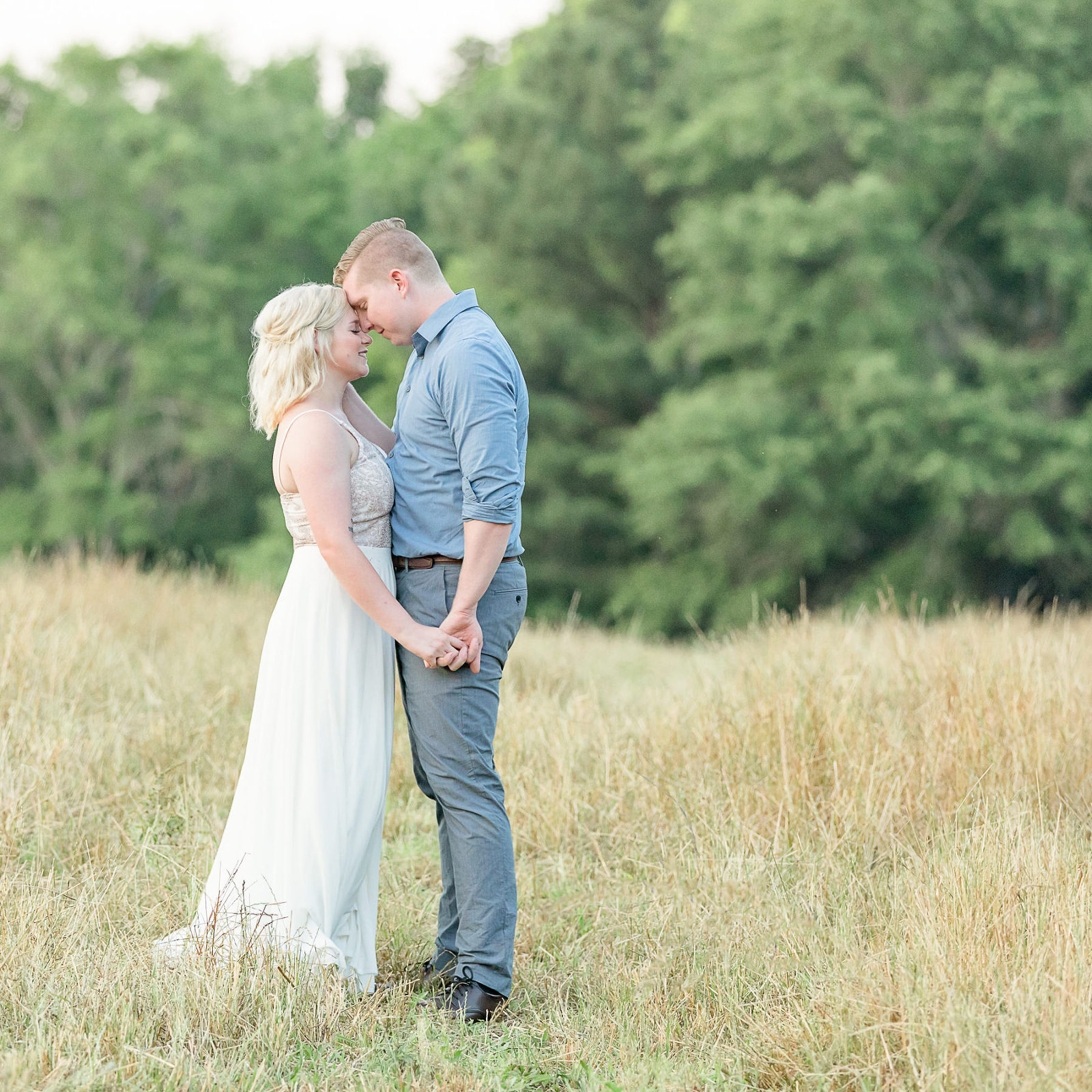 engaged couple in field white dress